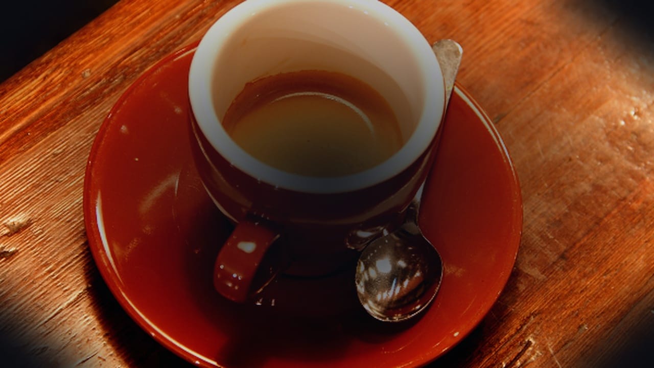 Warm rustic cup of coffee on wooden table illustrating habit trigger decoupling for morning smokers